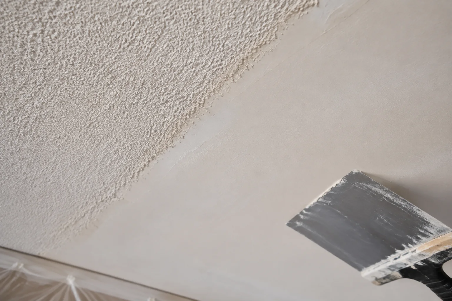 Representative close-up showing popcorn texture beside a freshly skim-coated smooth ceiling surface