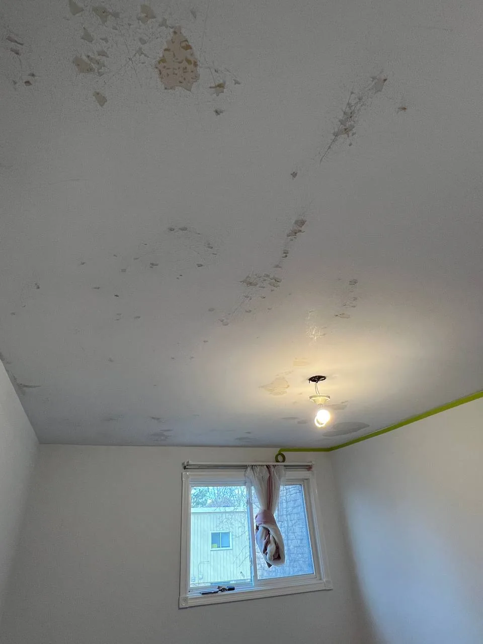 Severely peeling ceiling paint before repair